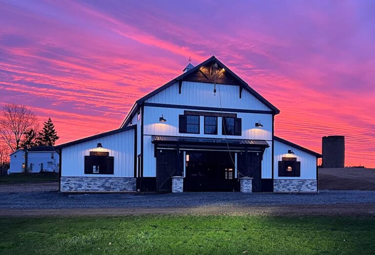 white barn with pink sunset in background